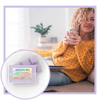 Thumbnail for Calm woman in yellow sweater holding a mug with a box of Calming Wax Melts in the foreground.