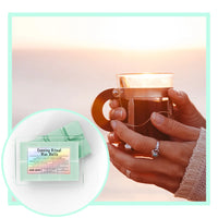Thumbnail for Hot drink being held with a close-up of evening ritual wax melts packaging on a soft gradient background