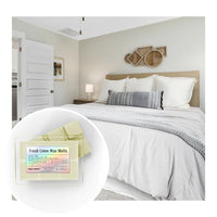 Thumbnail for Bedroom with a bed and nightstand, featuring 'Fresh Linen Wax Melts' packaging.