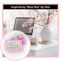 Thumbnail for Miss feminine wax melts inspired by 'Miss Dior' by Dior on a desk with flowers and a computer.